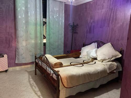 a bedroom with a bed with purple walls at Appartement lumineux in Marrakesh