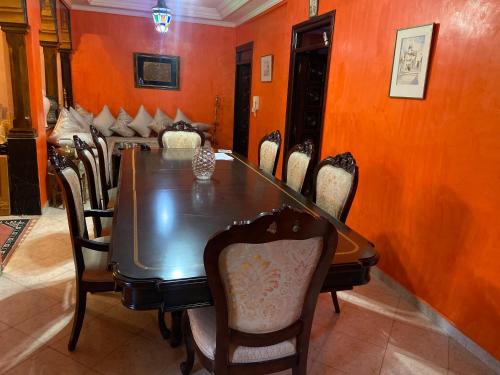 a dining room with a wooden table and chairs at Appartement lumineux in Marrakesh