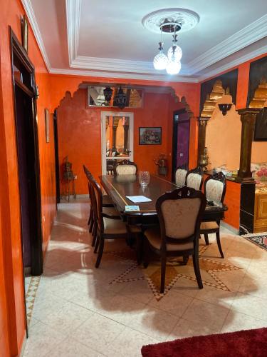 a dining room with a wooden table and chairs at Appartement lumineux in Marrakesh