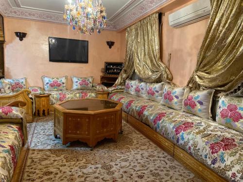 a living room with couches and a tv at Appartement lumineux in Marrakesh