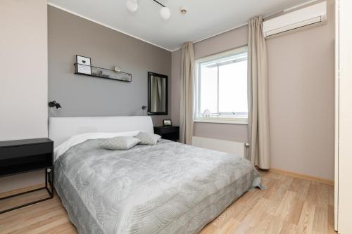 biała sypialnia z łóżkiem i oknem w obiekcie Viru Stylish Apartment w Tallinnie