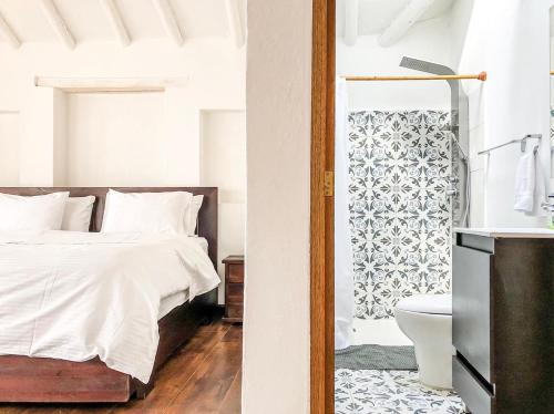 a white bedroom with a bed and a toilet at CASA DE LAS MATERAS in Villa de Leyva