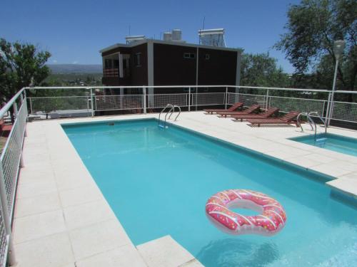 una gran piscina con una balsa inflable. en La Villa Inn en Villa Carlos Paz