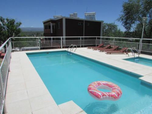 a large swimming pool with a inflatable raft in it at La Villa Inn in Villa Carlos Paz