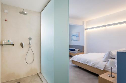 a bedroom with a bed and a glass wall at Alti Santorini Suites - Caldera View in Megalochori