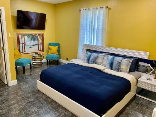 Schlafzimmer mit einem Bett, einem TV und Stühlen in der Unterkunft Villa Harley Summer in Cape Coral