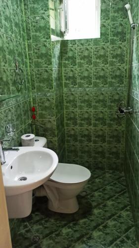 a green tiled bathroom with a toilet and a sink at Arode Villa Ovidius - Apartments in Balchik