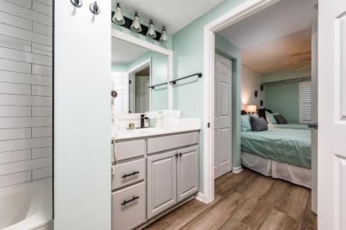 a bathroom with a sink and a mirror and a bed at Unit 1207 Ocean Walk - 1 Bedroom Ocean Front in Daytona Beach