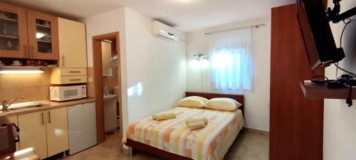 ein kleines Schlafzimmer mit einem Bett mit zwei Kissen in der Unterkunft Dinka Apartment in Trogir