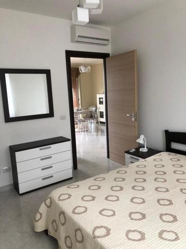 a bedroom with a bed and a dresser and a mirror at Apartment Napitia Hills in Pizzo
