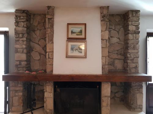 sala de estar con chimenea de piedra y 2 cuadros en la pared en Armida, en Pescasseroli