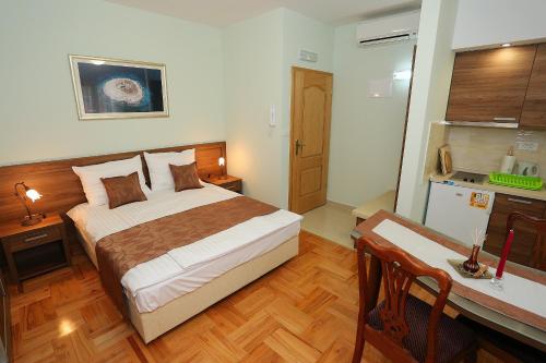 a bedroom with a bed and a desk and a kitchen at Apartments Ivana - Iva in Zadar