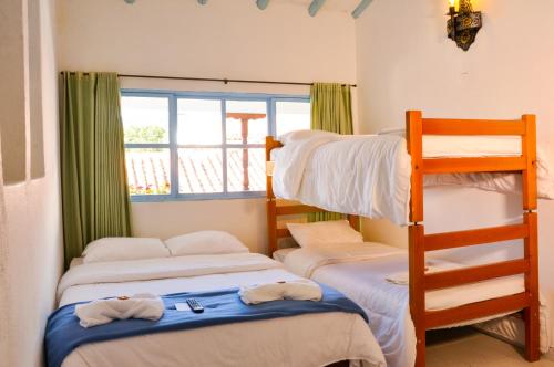 a bedroom with three bunk beds and a ladder at Laureles de la Villa in Villa de Leyva