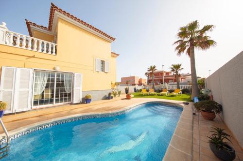 a swimming pool in front of a house at MEDANO4YOU Casa Girasol in El Médano