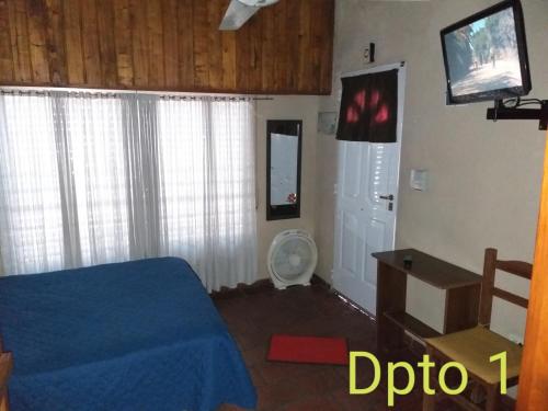 a bedroom with a bed and a tv on the wall at Apartamento El Calvario 1 in Tandil