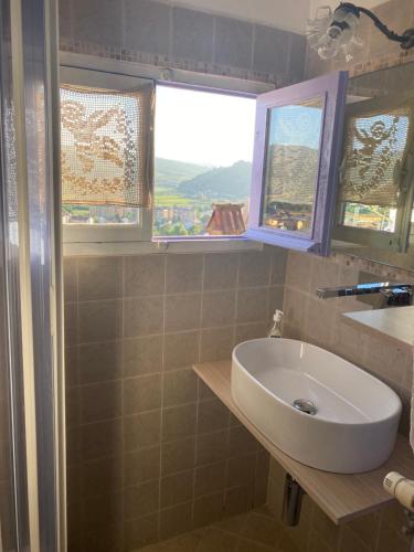 ein Badezimmer mit Waschbecken und zwei Fenstern in der Unterkunft View & Wine Room in Canelli
