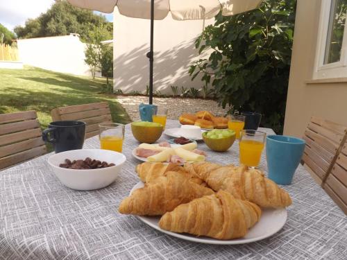 a table with croissants and other breakfast foods on it at Casal do Pinheiro in Óbidos
