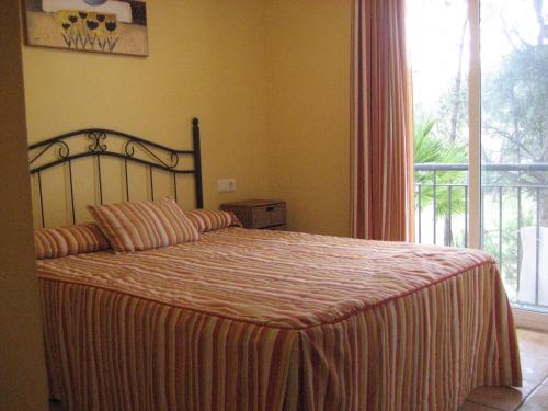 sypialnia z dużym łóżkiem i dużym oknem w obiekcie Residencial Golf Playa IV w mieście Islantilla
