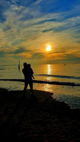 a couple hugging on the beach at sunset at Gabriel Guesthouse in Rhyl