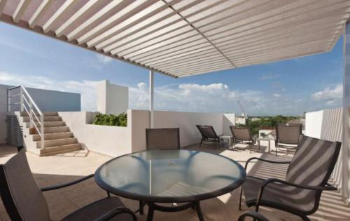 莫雷洛斯港的住宿－Ocean Villa，一个带玻璃桌和椅子的庭院