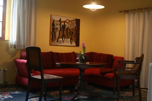 ドレスデンにあるPoncet´sches Herrenhausのリビングルーム(赤いソファ、テーブル付)