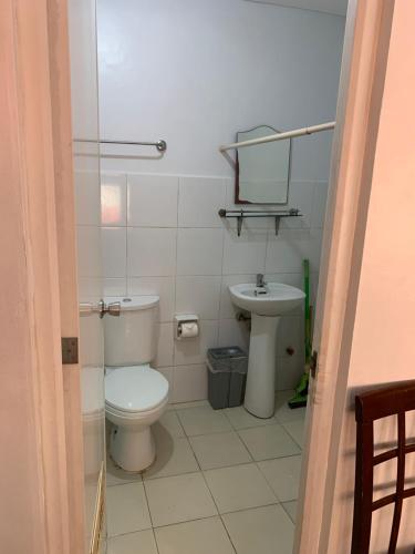 a small bathroom with a toilet and a sink at CTUB Espana Manila in Manila