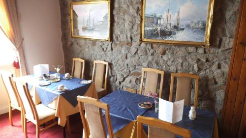 uma sala de jantar com uma mesa azul e cadeiras em Thalatta Guest House em St Clements