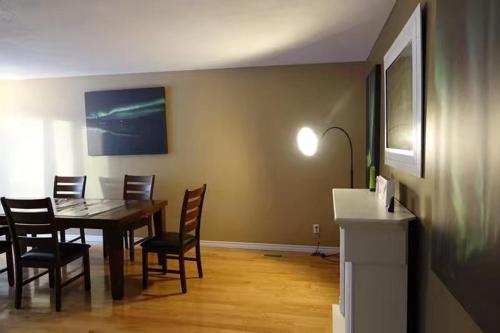 a dining room with a wooden table and chairs at YK Aurora in Yellowknife