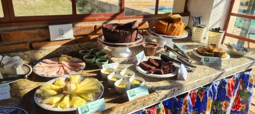 un buffet con torte e altri dolci su un tavolo di Pousada Sons do Silêncio a Socorro