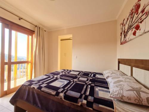1 dormitorio con cama y ventana en Vista Dutra, en Gramado