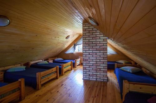 a room with six beds in a wooden house at Atpūtas komplekss Godeļi in Usma