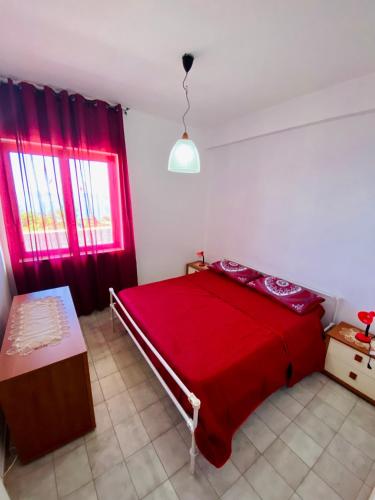 Schlafzimmer mit einem roten Bett und roten Vorhängen in der Unterkunft Vacanzlucido in San Lucido