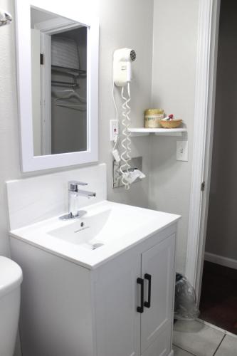 uma casa de banho branca com um lavatório e um espelho em Thunderbird Motel Las Vegas/ New Mexico em Las Vegas