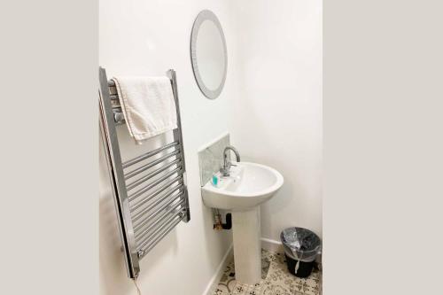 a white bathroom with a sink and a mirror at Sutton Contractor Accommodation - Warrington, St Helens in Clock Face