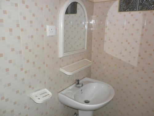 y baño con lavabo y espejo. en McCarthy Guesthouse, en Kandy