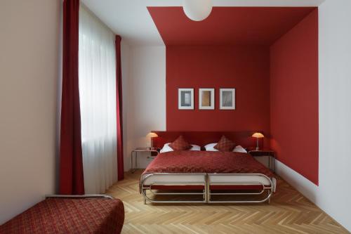 a red bedroom with a bed with red walls at AXA Hotel in Prague