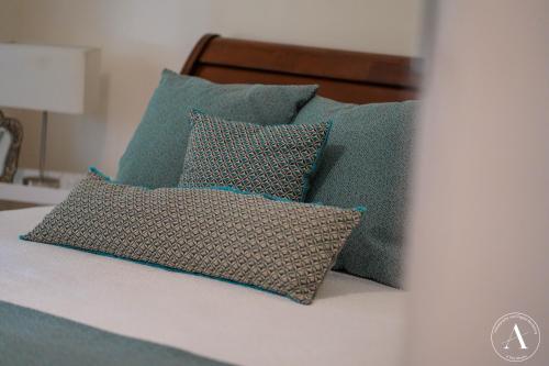 un grupo de almohadas sentadas en una cama en The Vigneron Villa en Woodside