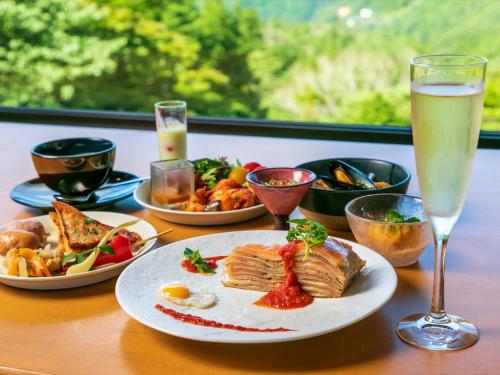 a table with a plate of food and a glass of champagne at barhotel Hakone Kazan in Hakone