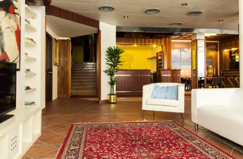 a lobby with a white chair and a rug at Hotel Merano in Grado