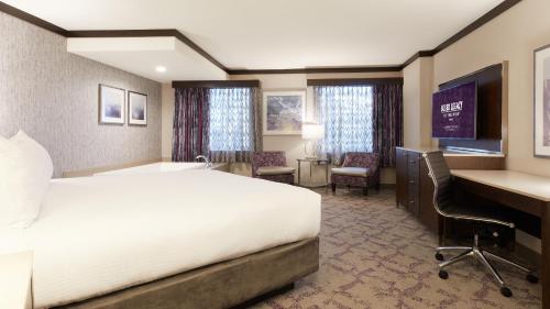 a hotel room with a bed and a desk at Silver Legacy Reno, A Caesars Destination in Reno
