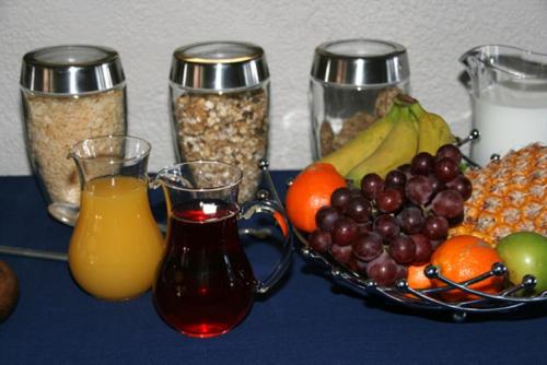 a table with a bowl of fruit and glasses of orange juice at Majorca House in Somerset West