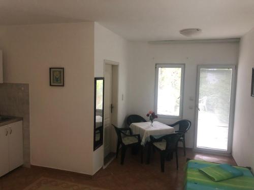 a dining room with a table and chairs in a room at Apartmani Sunce in Bar