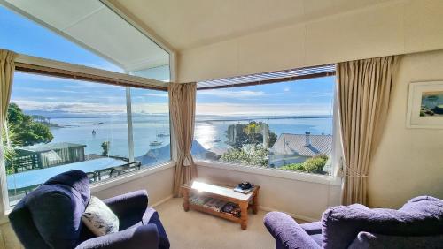 a living room with a large window with a view of the ocean at Kimberley Three - Nelson Waterfront Penthouse in Nelson