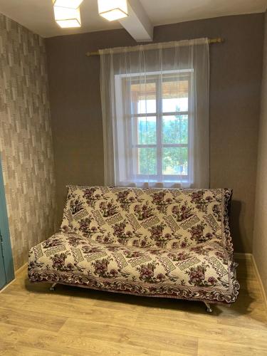 a bed in a room with a window at Соколине Гніздо in Dmitrenki