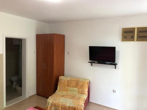a living room with a tv and a chair at Apartmani Sunce in Bar