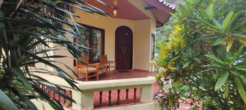 a front porch of a house with a table and chairs at Bara Beach Bungalows in Bira