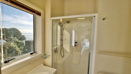 a bathroom with a shower and a sink and a window at Kimberley Three - Nelson Waterfront Penthouse in Nelson