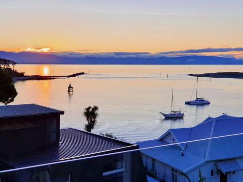 a group of boats in the water at sunset at Kimberley Three - Nelson Waterfront Penthouse in Nelson