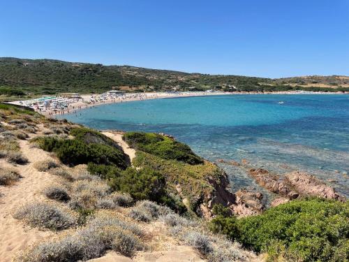 a beach with a bunch of people in the water at Carrabean sea in the North of Sardegna, with swimming pool in Viddalba