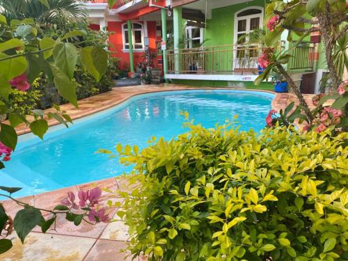 a large blue swimming pool in front of a house at Charming Apartment in Pereybere with Shared Pool, 75 m² in Pereybere